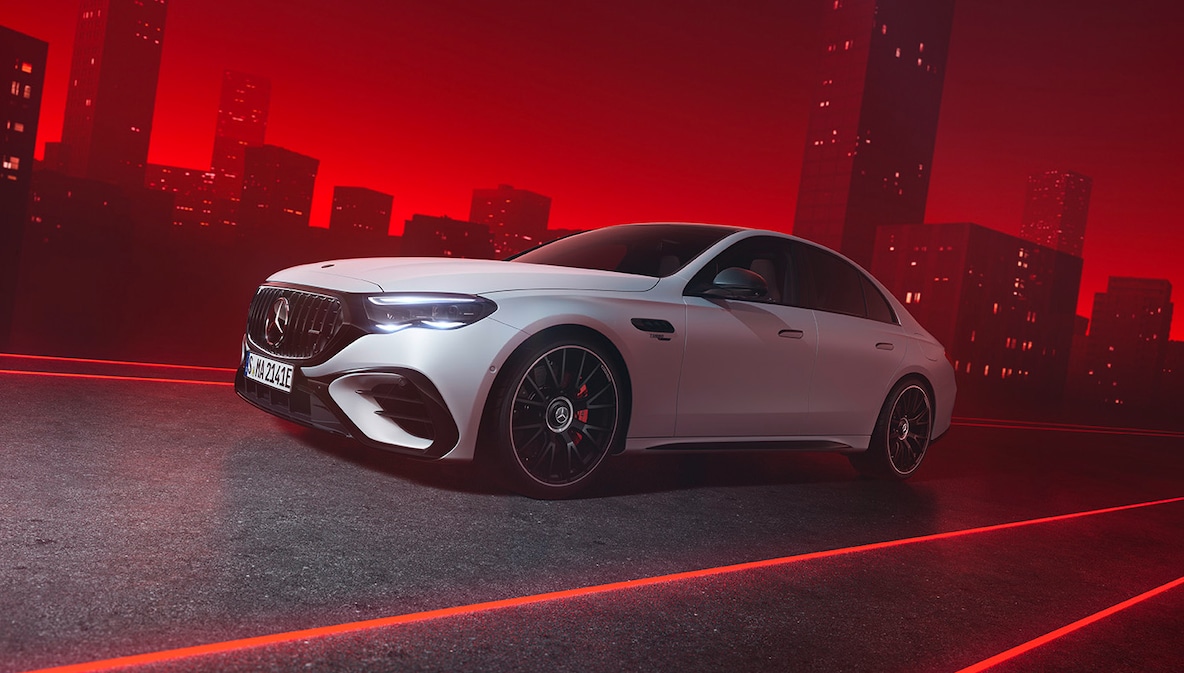 Mercedes-AMG E 53 HYBRID 4MATIC+ 在紅色背景下從上方視角看的車頭視圖。