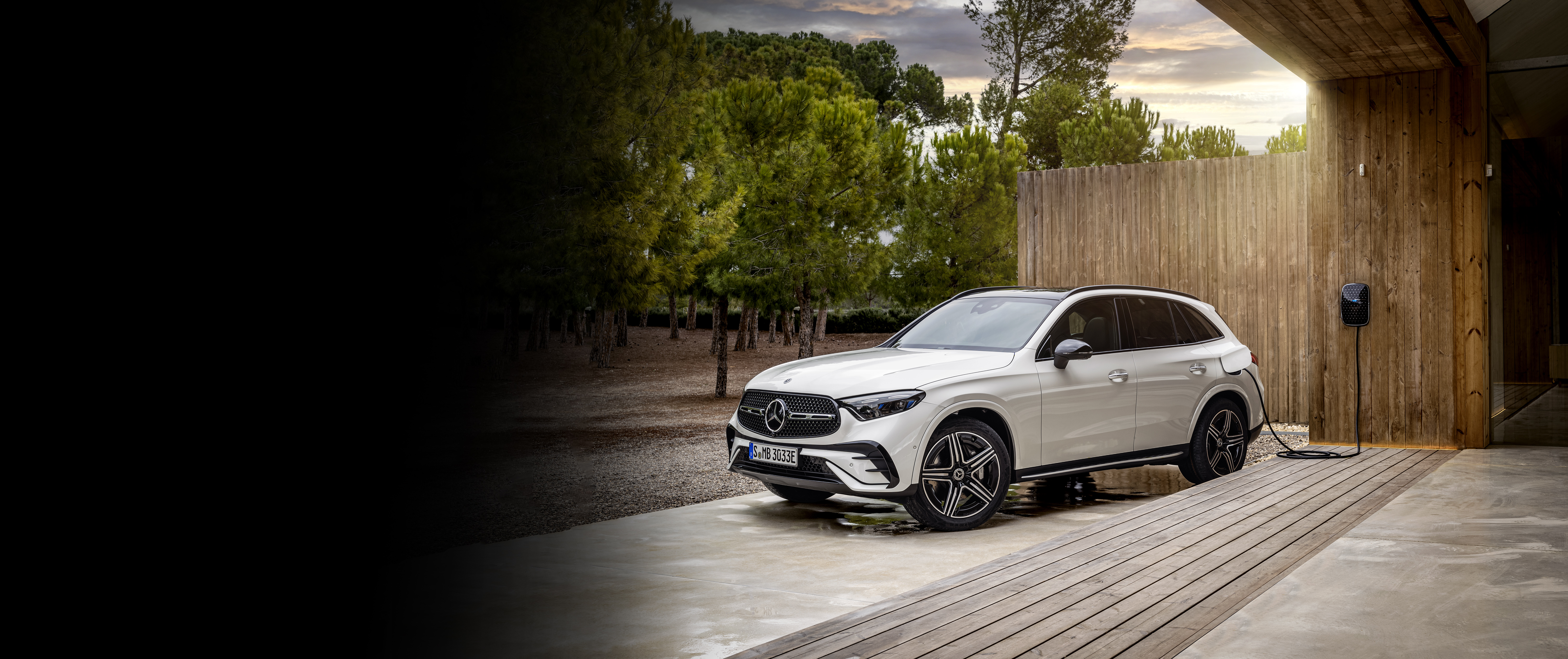 Plug-In Hybrids | Mercedes-Benz The Mercedes-Benz GLE SUV in a sidehot in front of a big house.