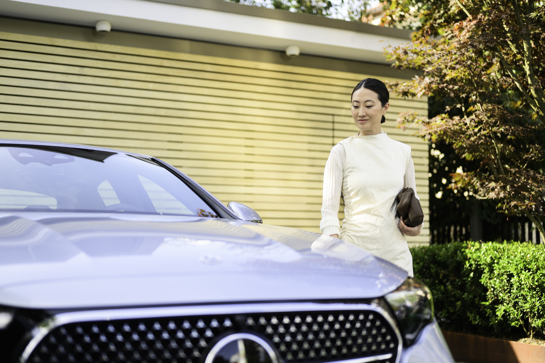 A person standing next to a Mercedes-Benz vehicle. Latest offer for EQ models from Mercedes-Benz Financial Services