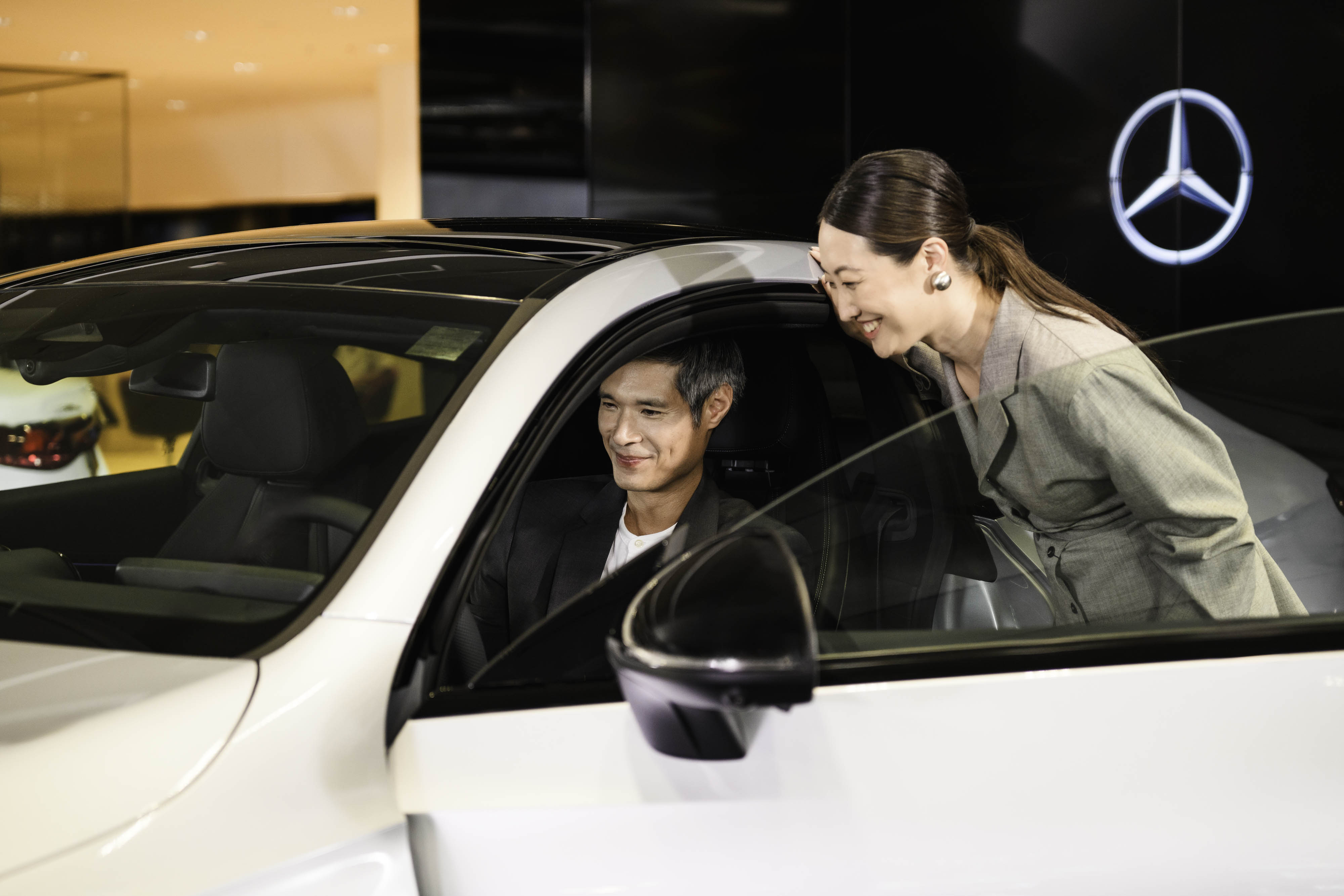 Agility, the best finance solution for your Mercedes-Benz A people sitting in a Mercedes-Benz vehicle and a person standing next to the car.