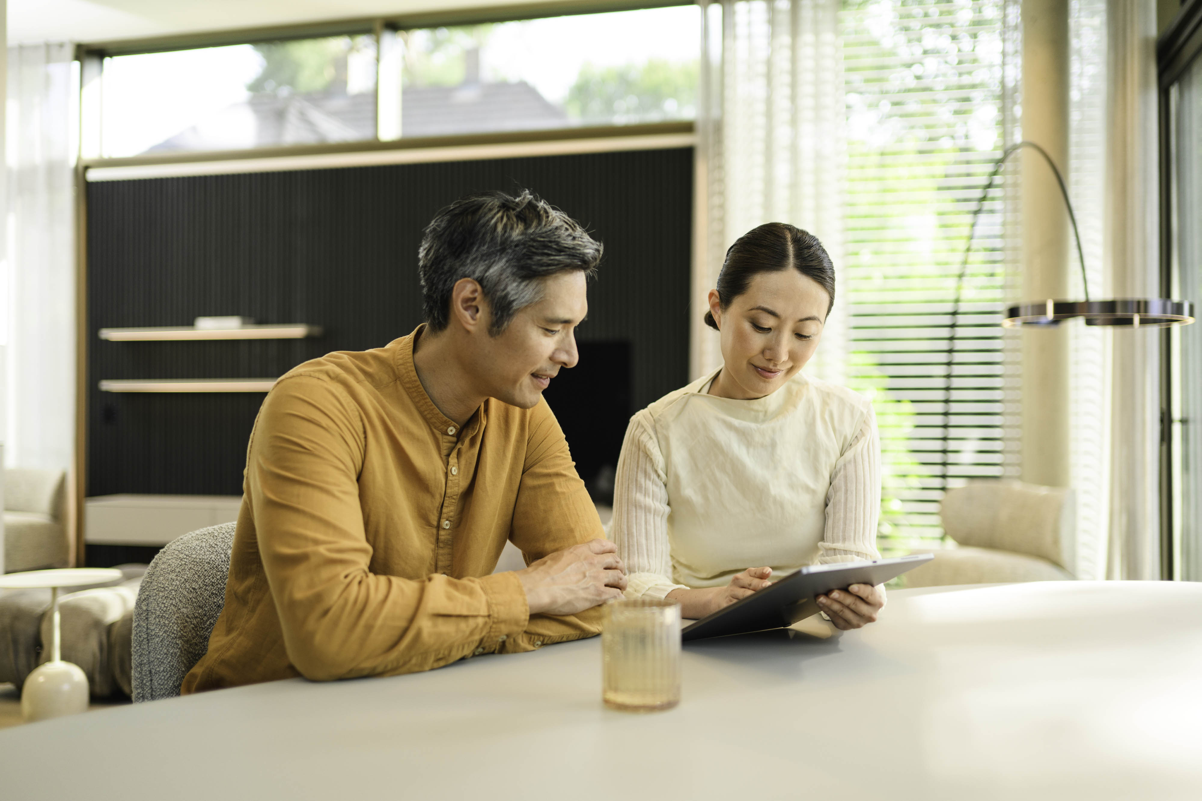 Latest offer of Mercedes-Benz Financial Services Two people sitting at a bench and looking at a mobile device.