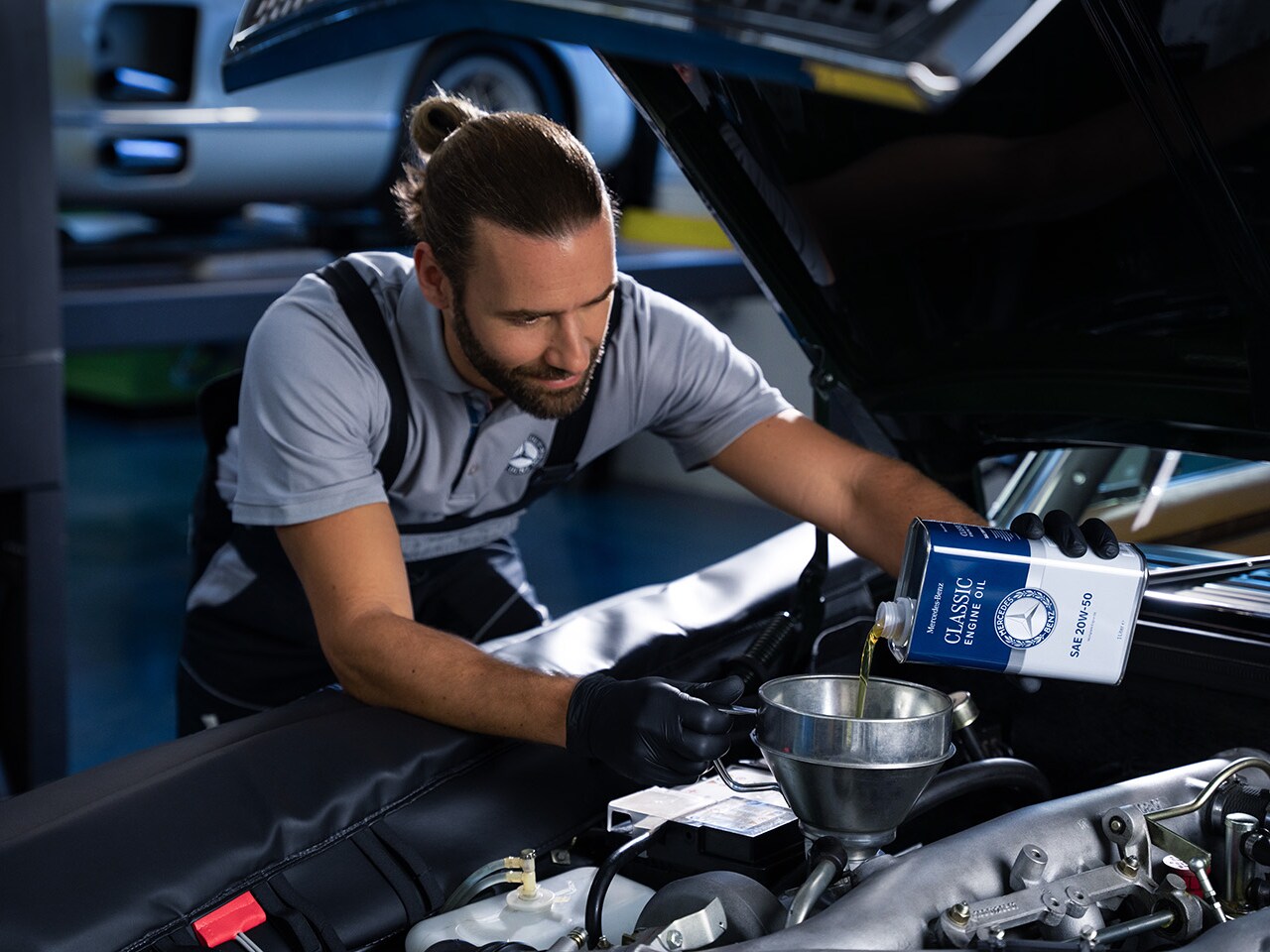 一位Mercedes-Benz員工正把專用機油倒入。