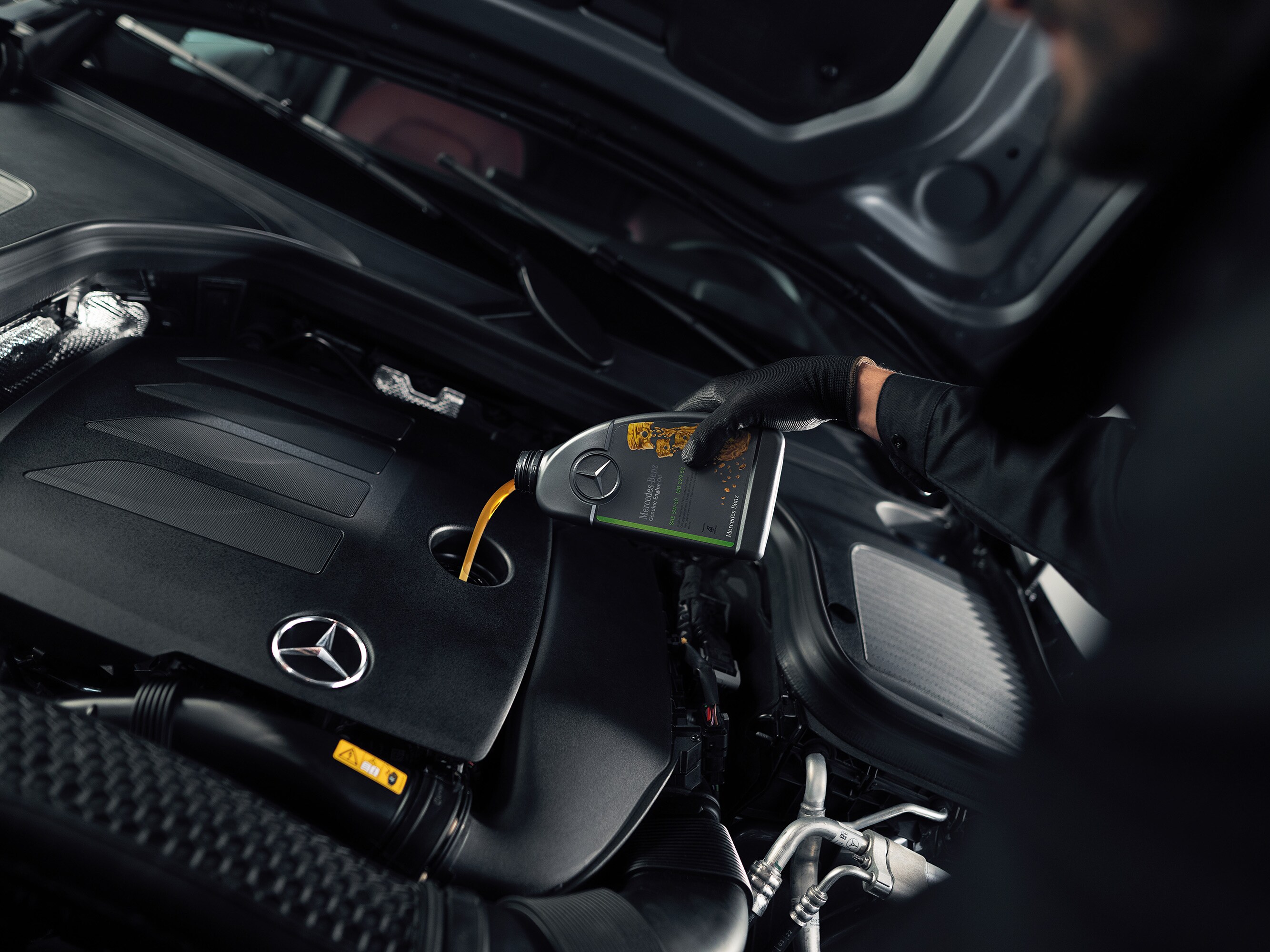 Mercedes-Benz技術人員加滿原廠引擎機油。