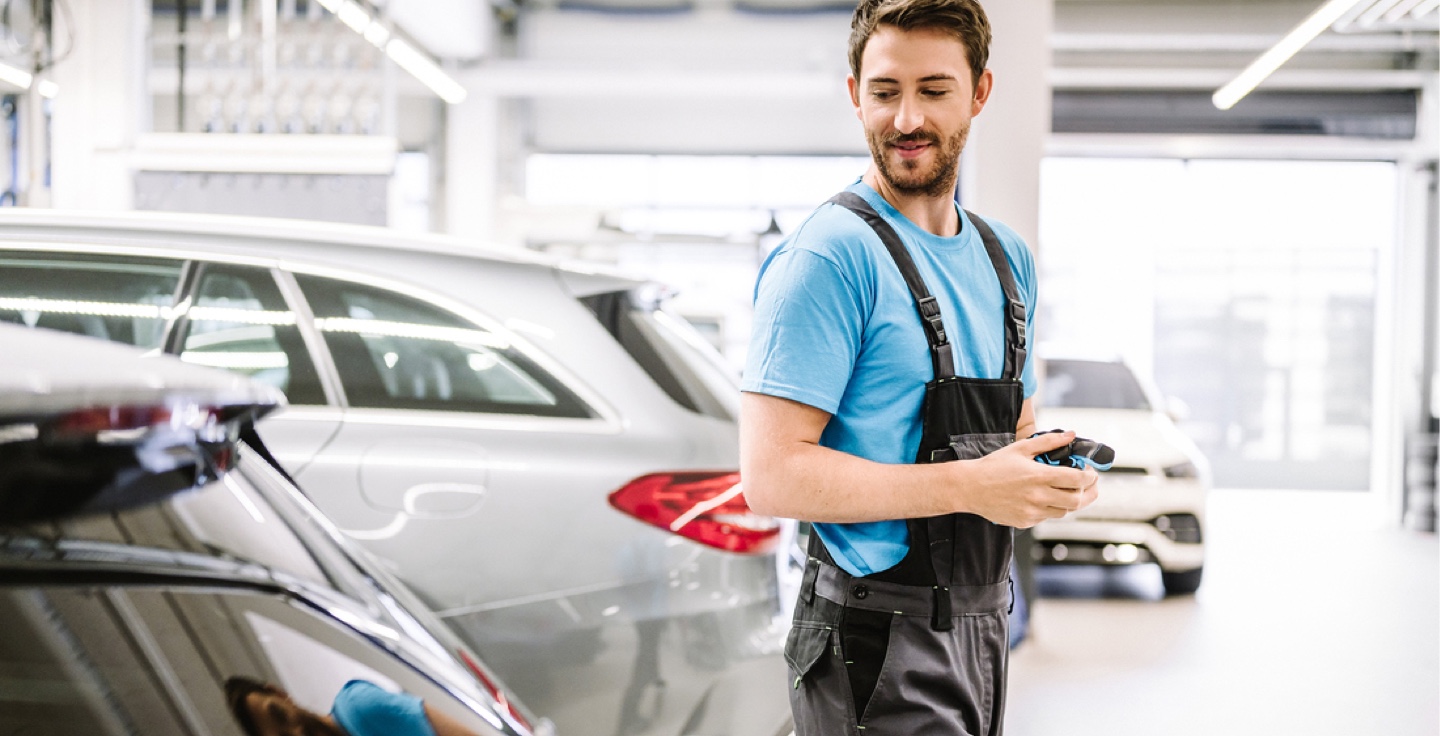 Damage and Breakdown assistance | Mercedes-Benz Woman standing in front of her Mercedes-Benz with her phone in her hand and being in a call