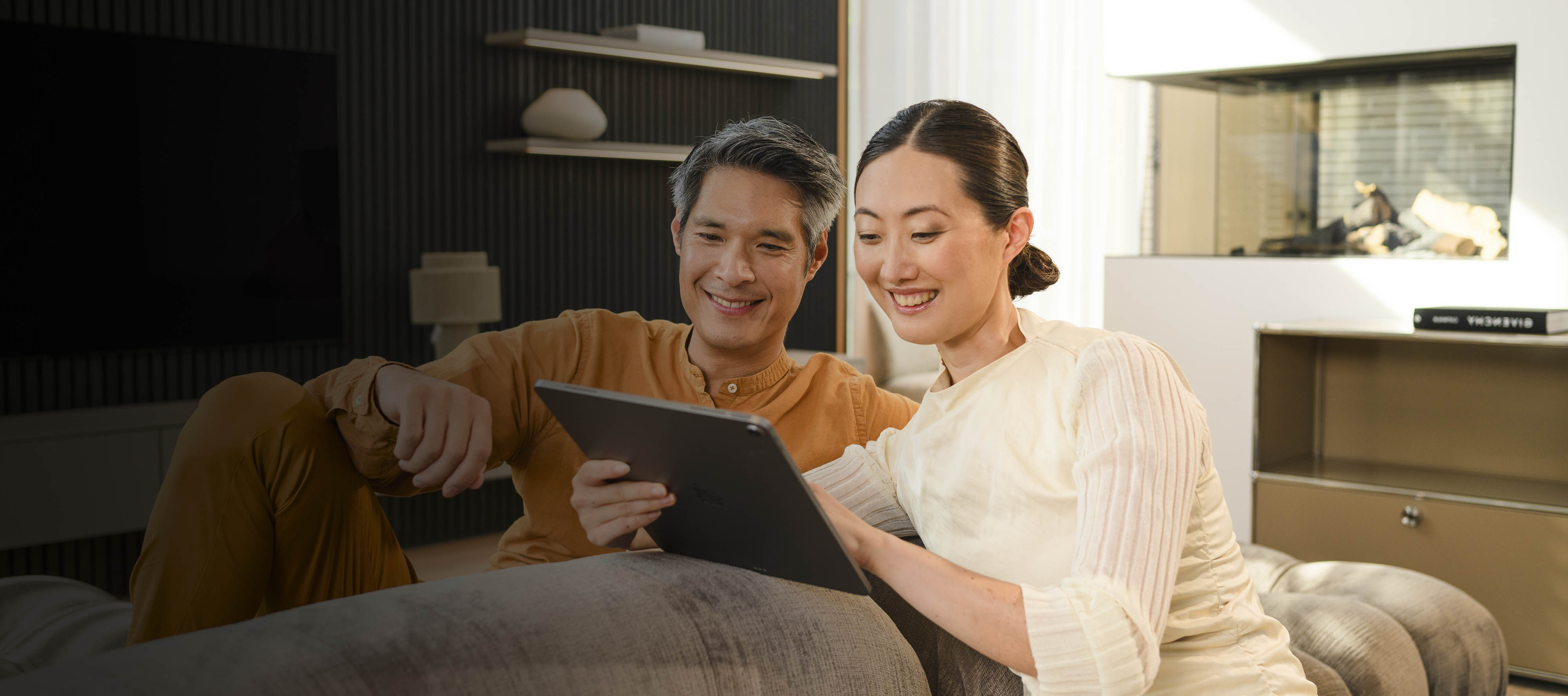 Financial services for your Mercedes-Benz Two people on a sofa looking at a mobile device.
