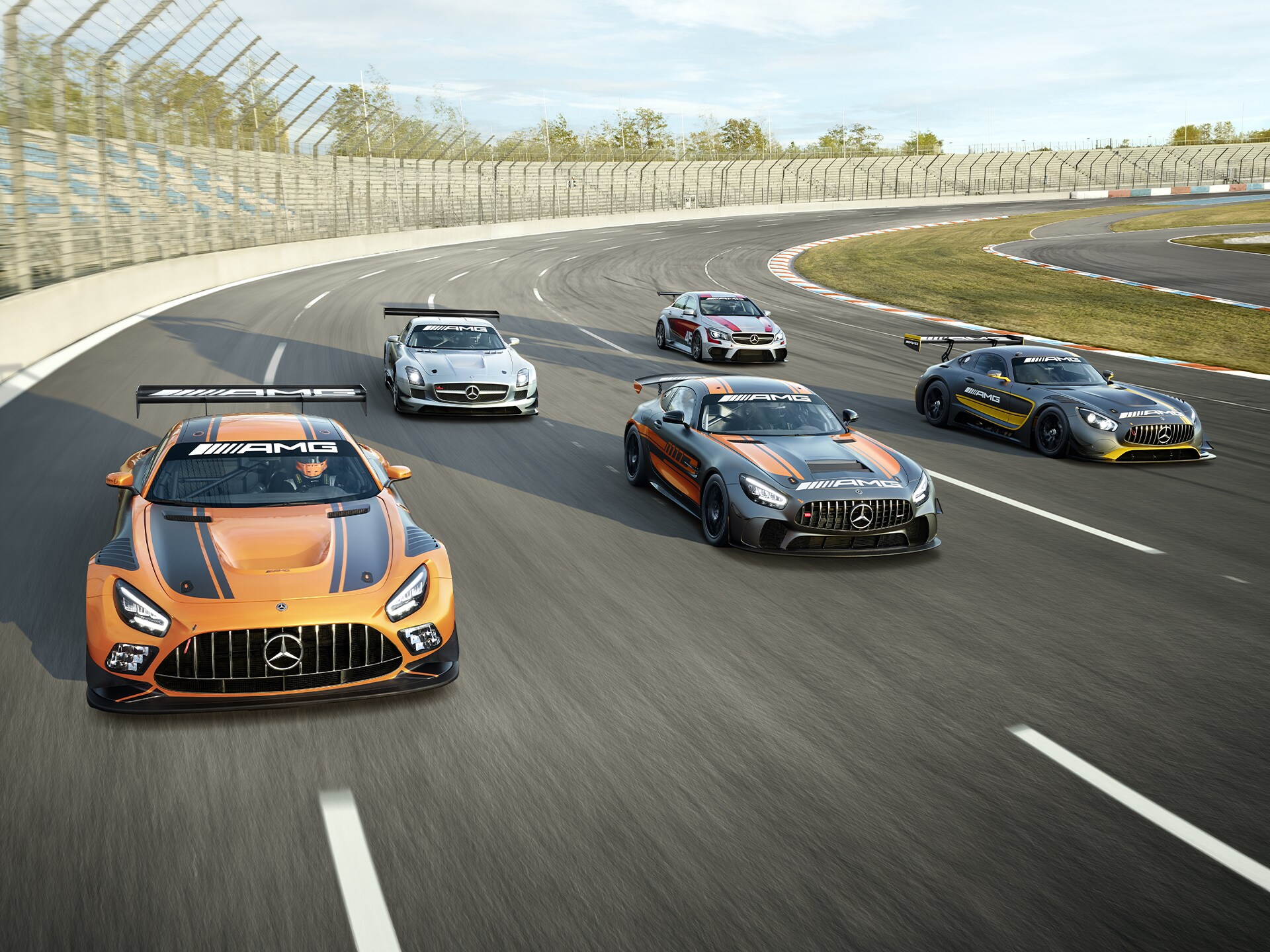 Several Mercedes-AMG vehicles on a race track.