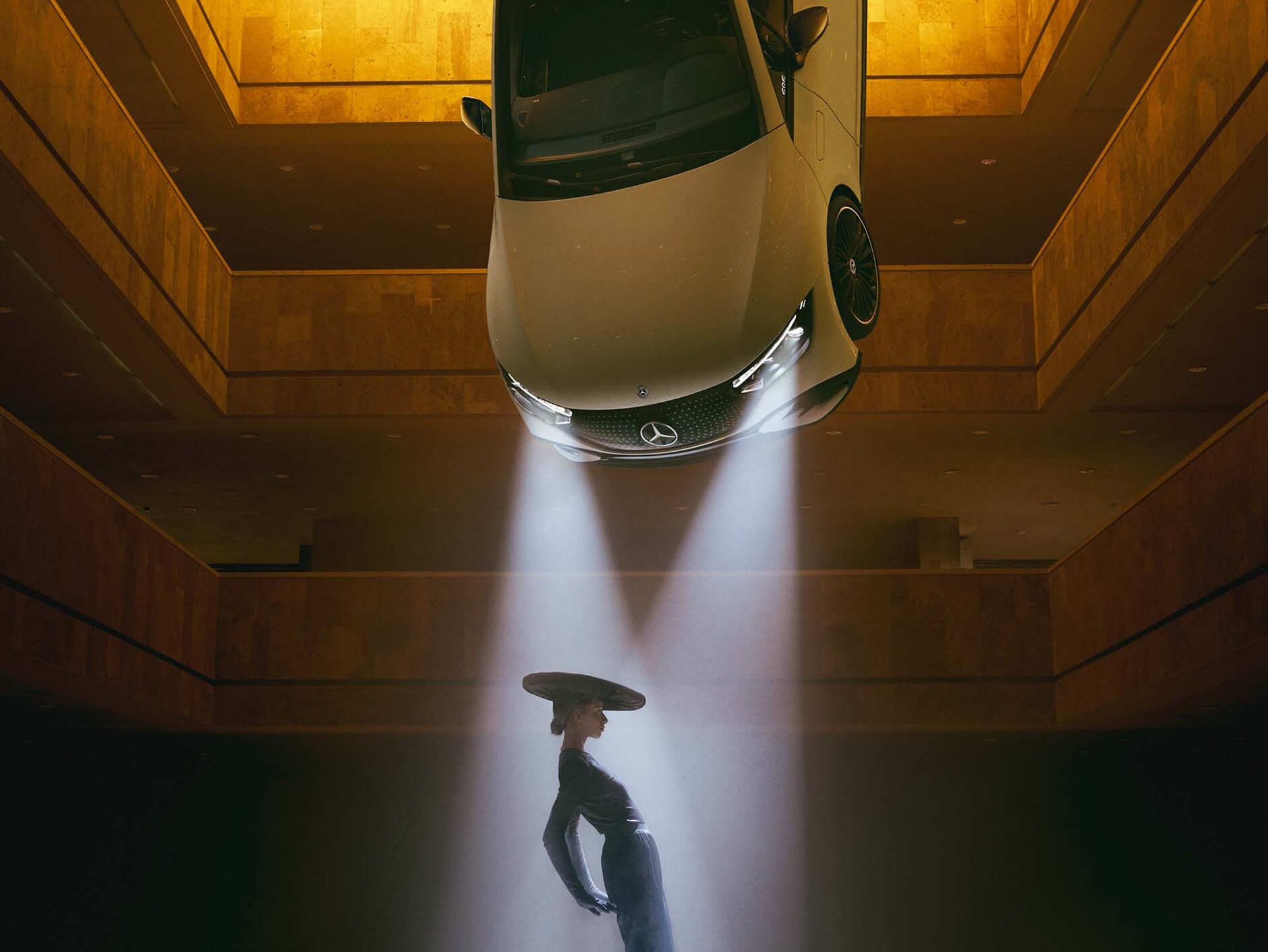 黑暗的房間中，天花板上掛著頭燈，一位女士站在光錐中。