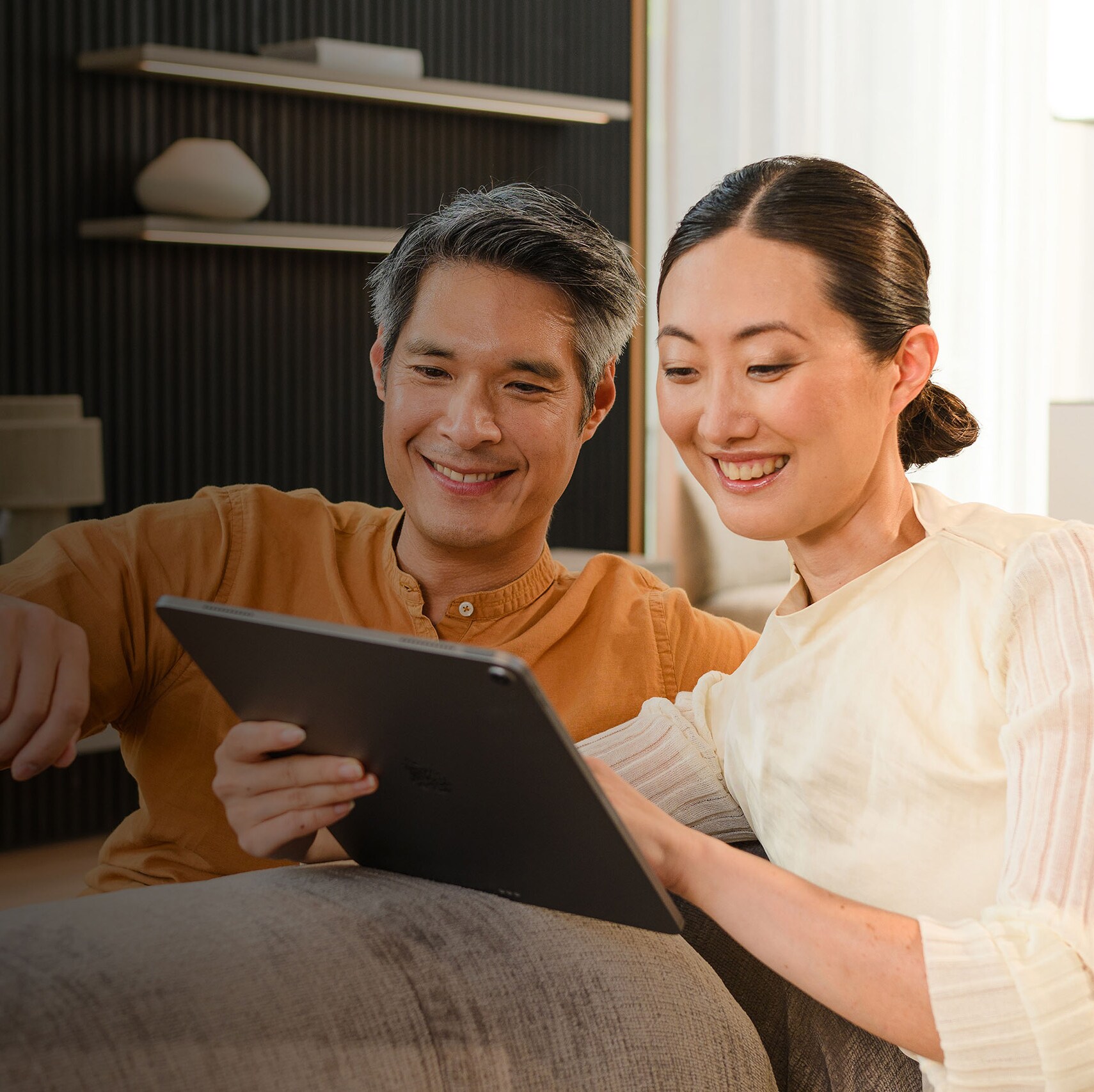 Two people on a sofa looking at a mobile device.
