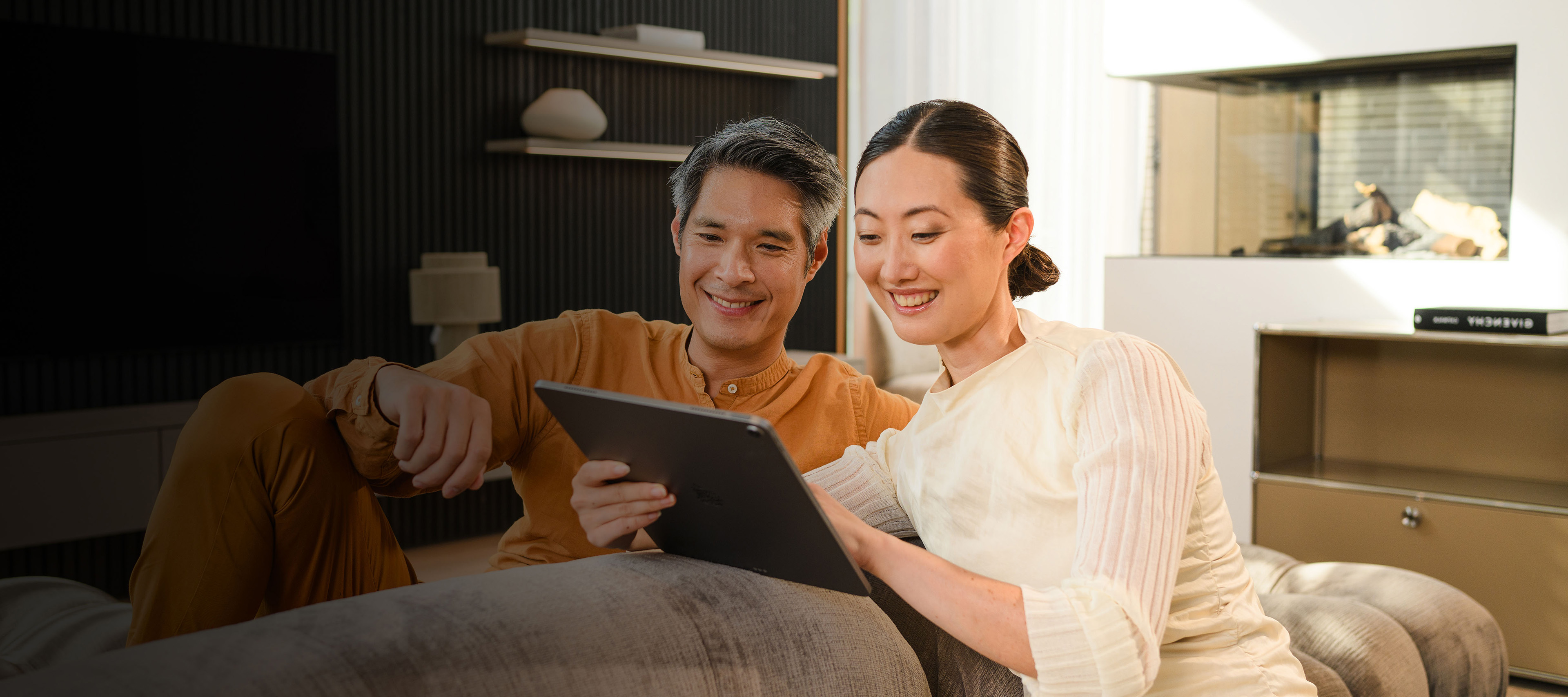 Financial services for your Mercedes-Benz Two people on a sofa looking at a mobile device.