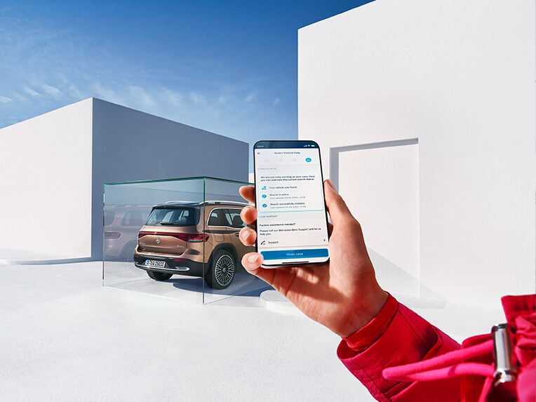 有人拿著智能手機，並使用Mercedes me App。背景停泊了一輛EQB。