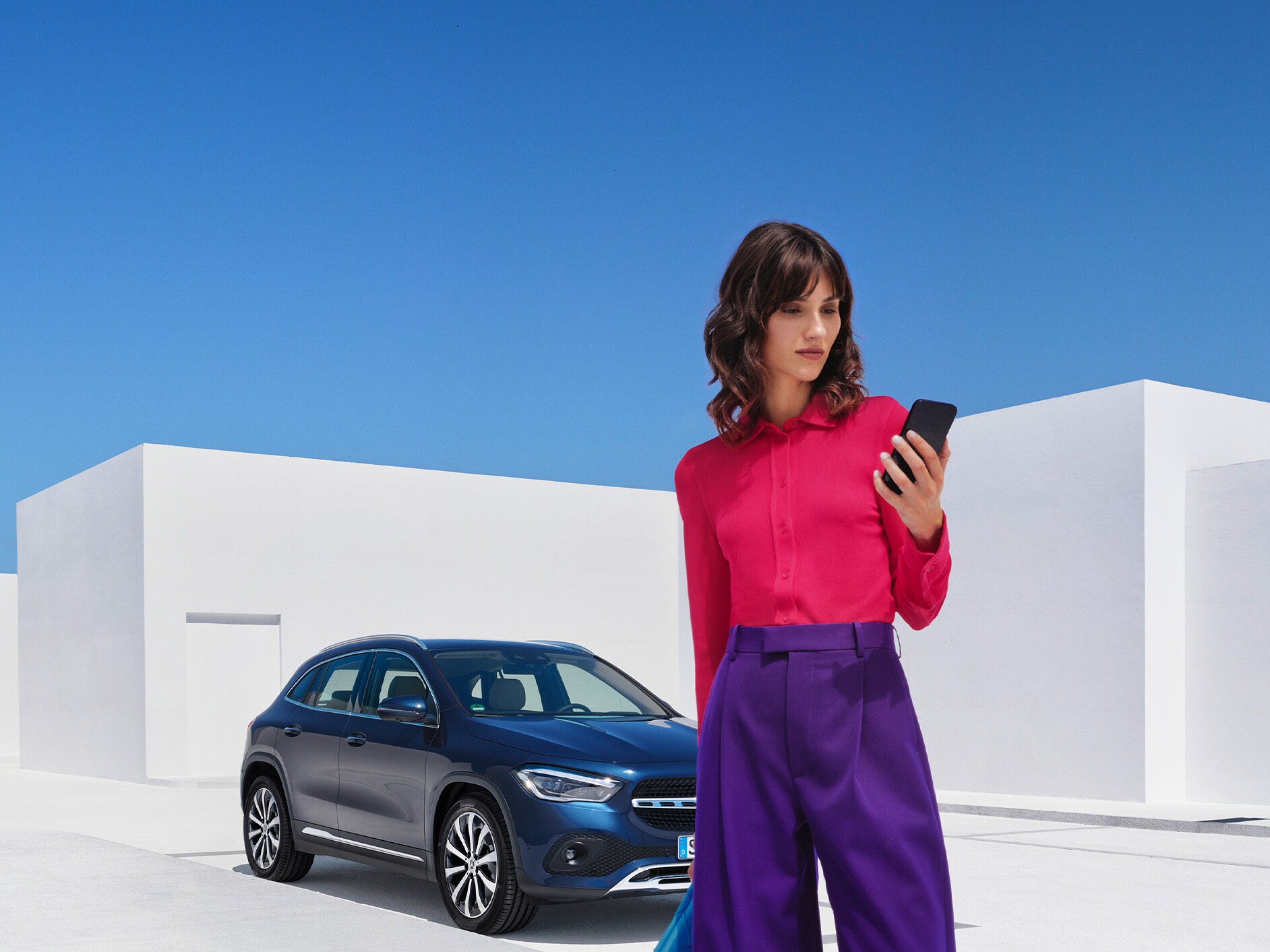 一位女士在她的智能手機上透過Mercedes me App與她的Mercedes-Benz座駕建立連線。