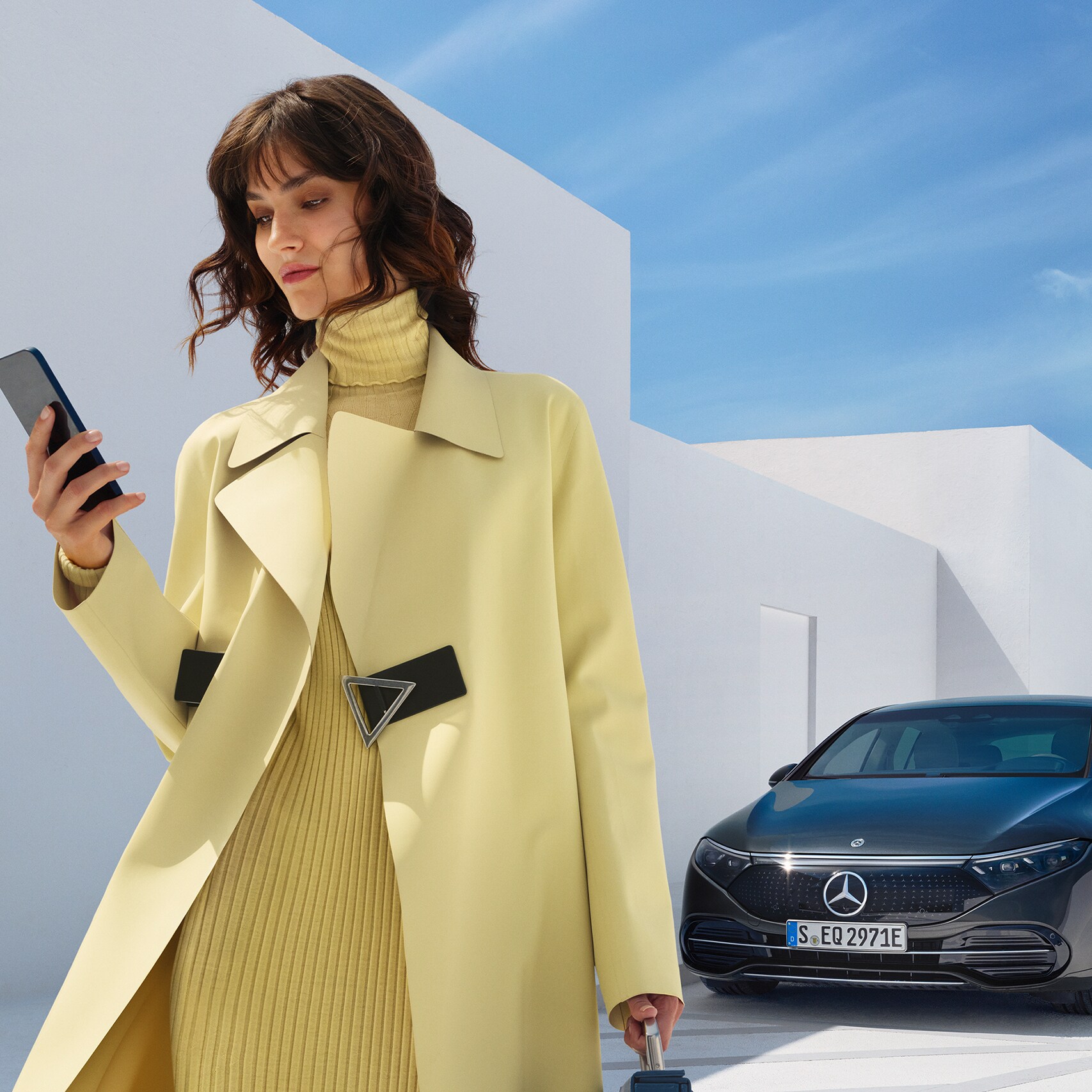 一位女士在智能手機上開啟Mercedes me App。