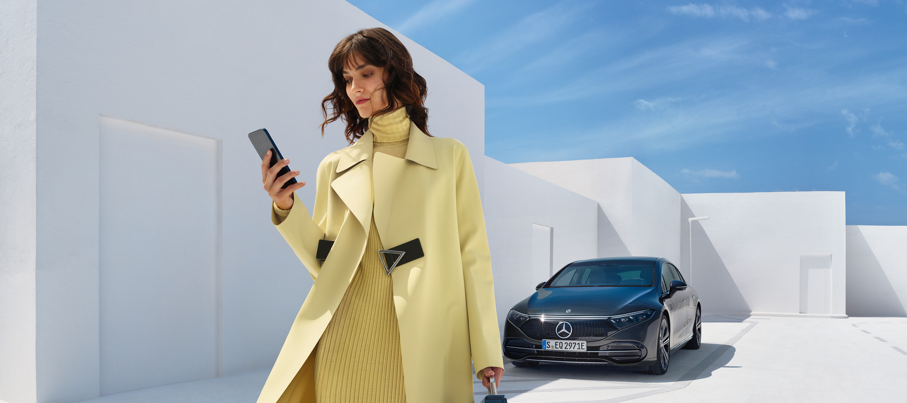 Mercedes me 一位女士在智能手機上開啟Mercedes me App。