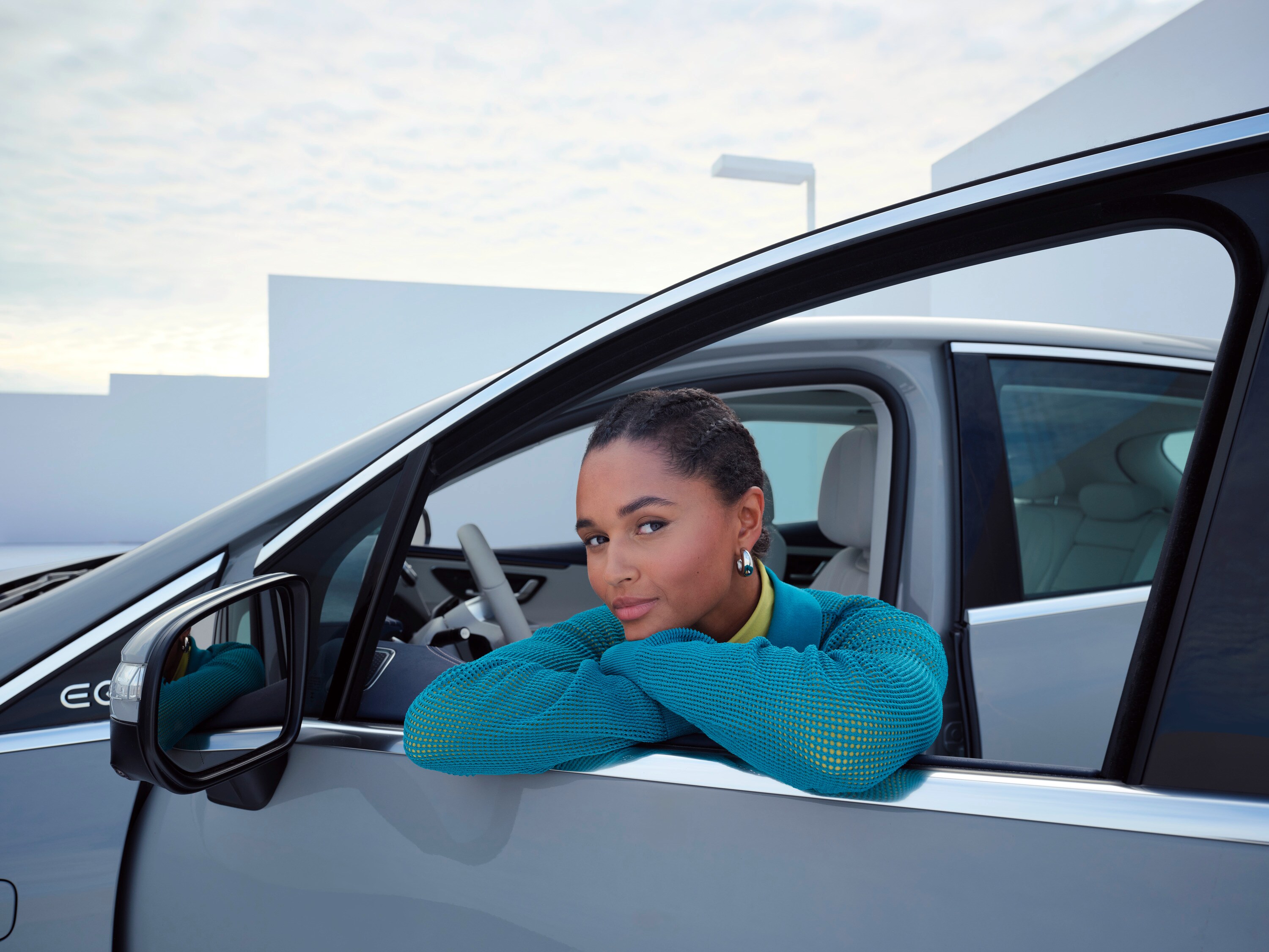 A person leaning in window of her Mercedes-Benz.