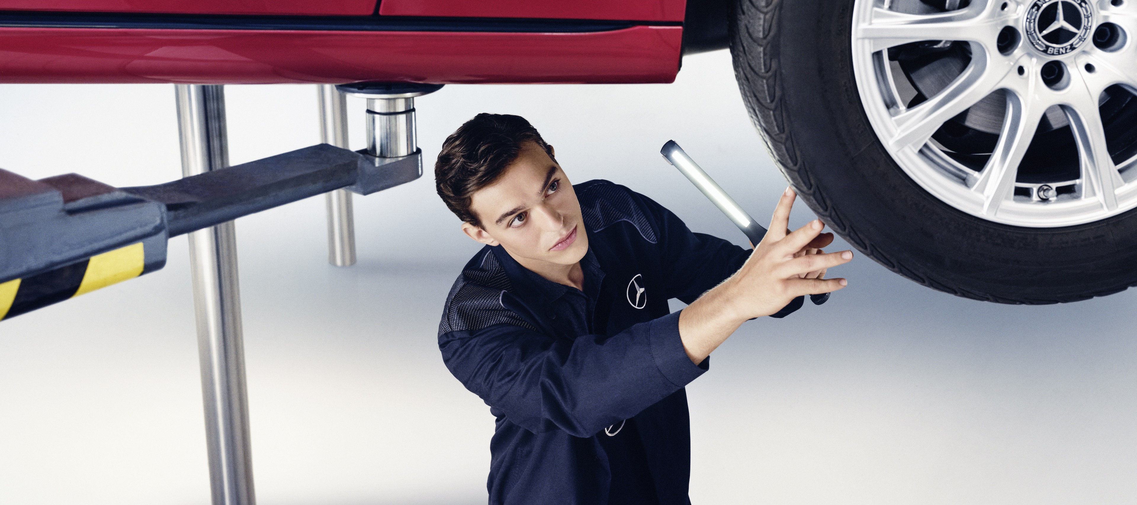 保養服務 | Mercedes-Benz 一位 Mercedes-Benz 機械師正在檢查一輛 Mercedes-Benz 的車輪。