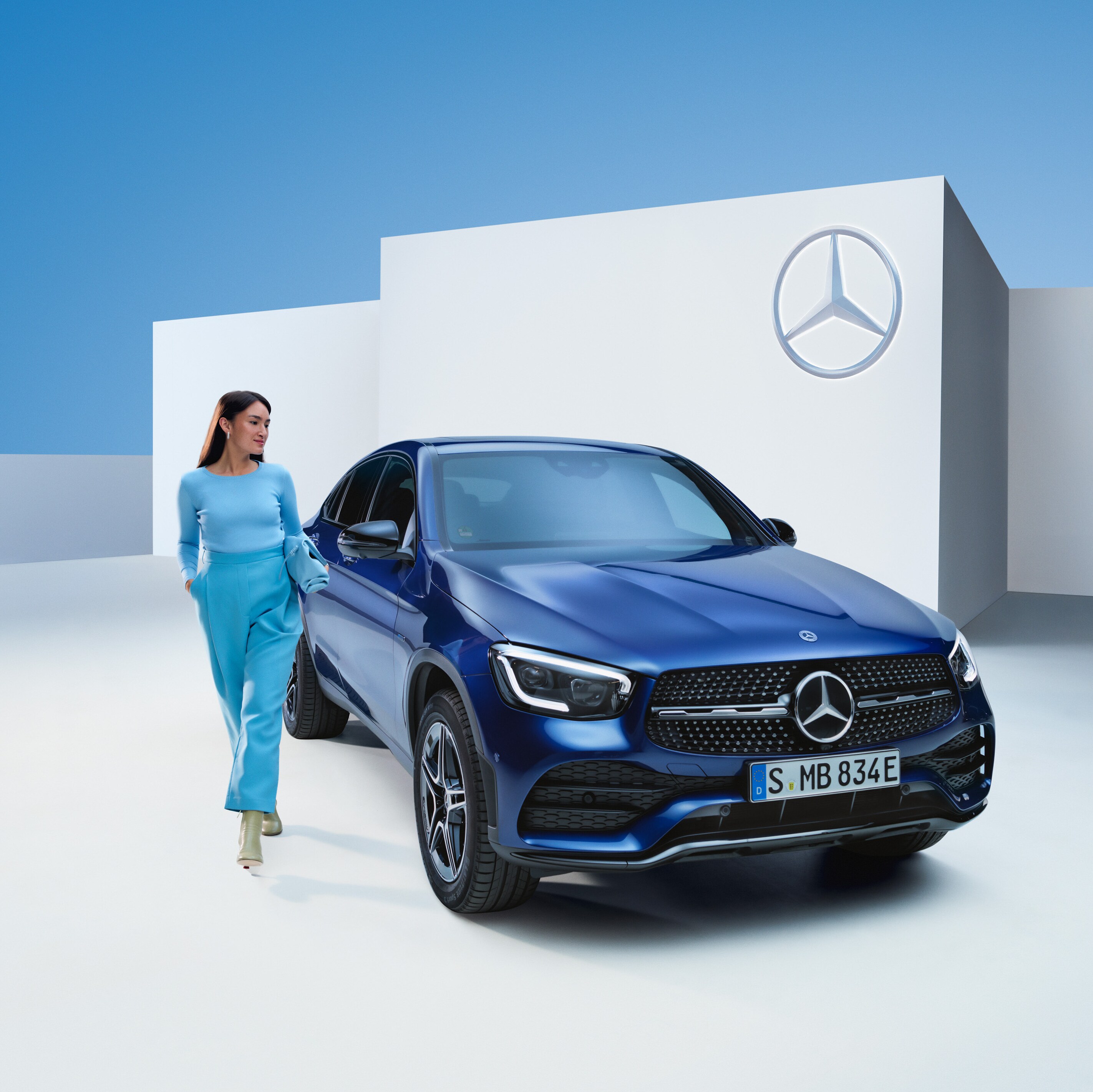 A walking person next to a Mercedes-Benz vehicle.