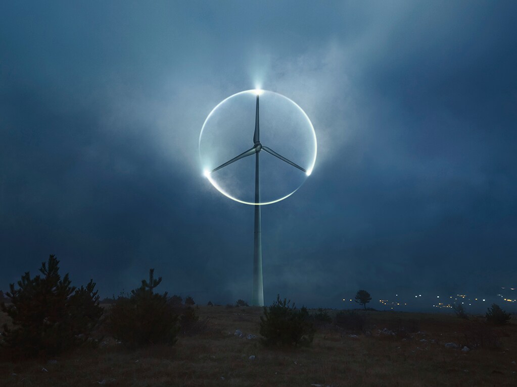 Woman standing in front of Mercedes-Benz EQ vehicle with the Hyperscreen hovering above her.