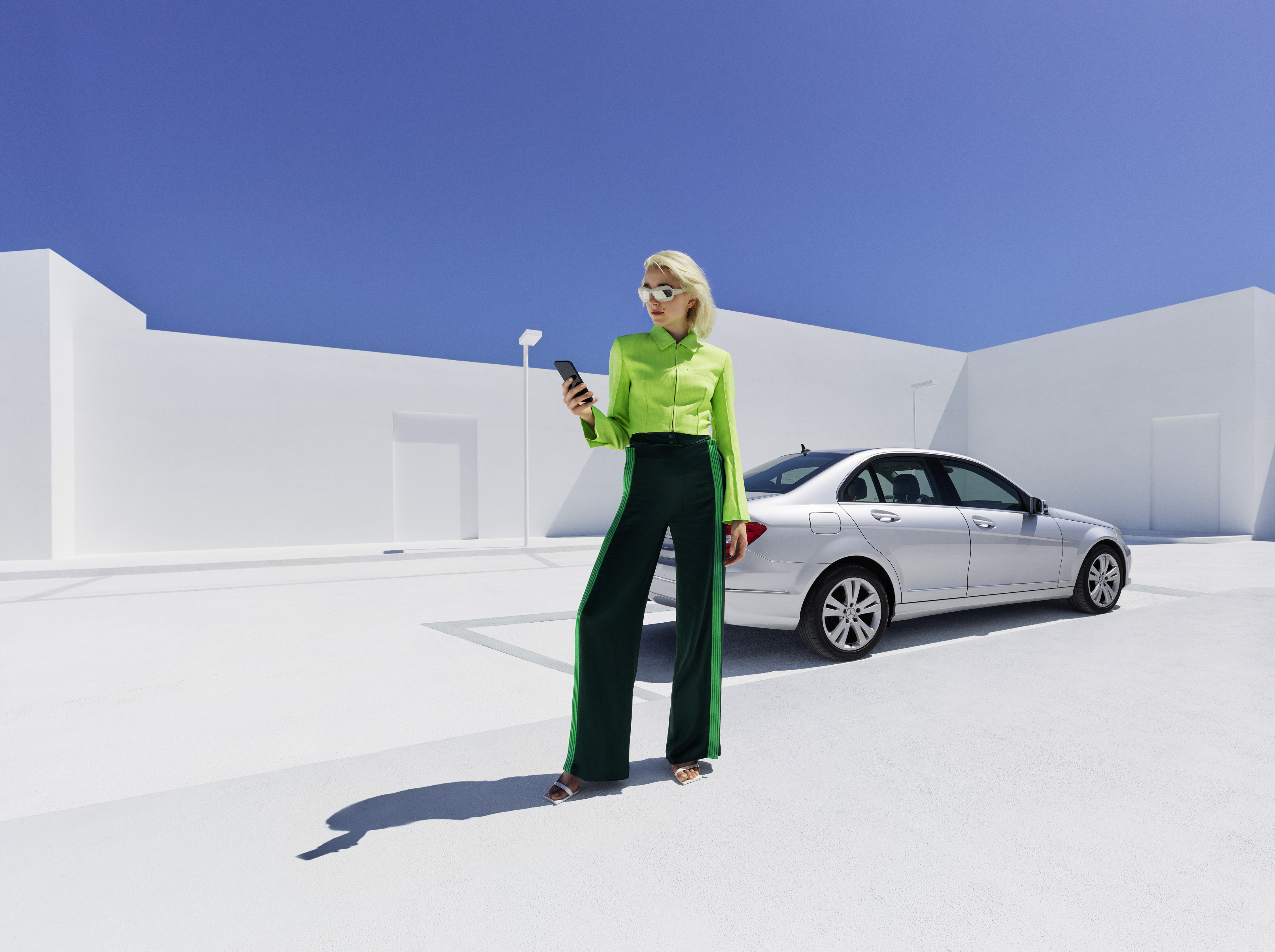 A lady holding mobile in front of a car