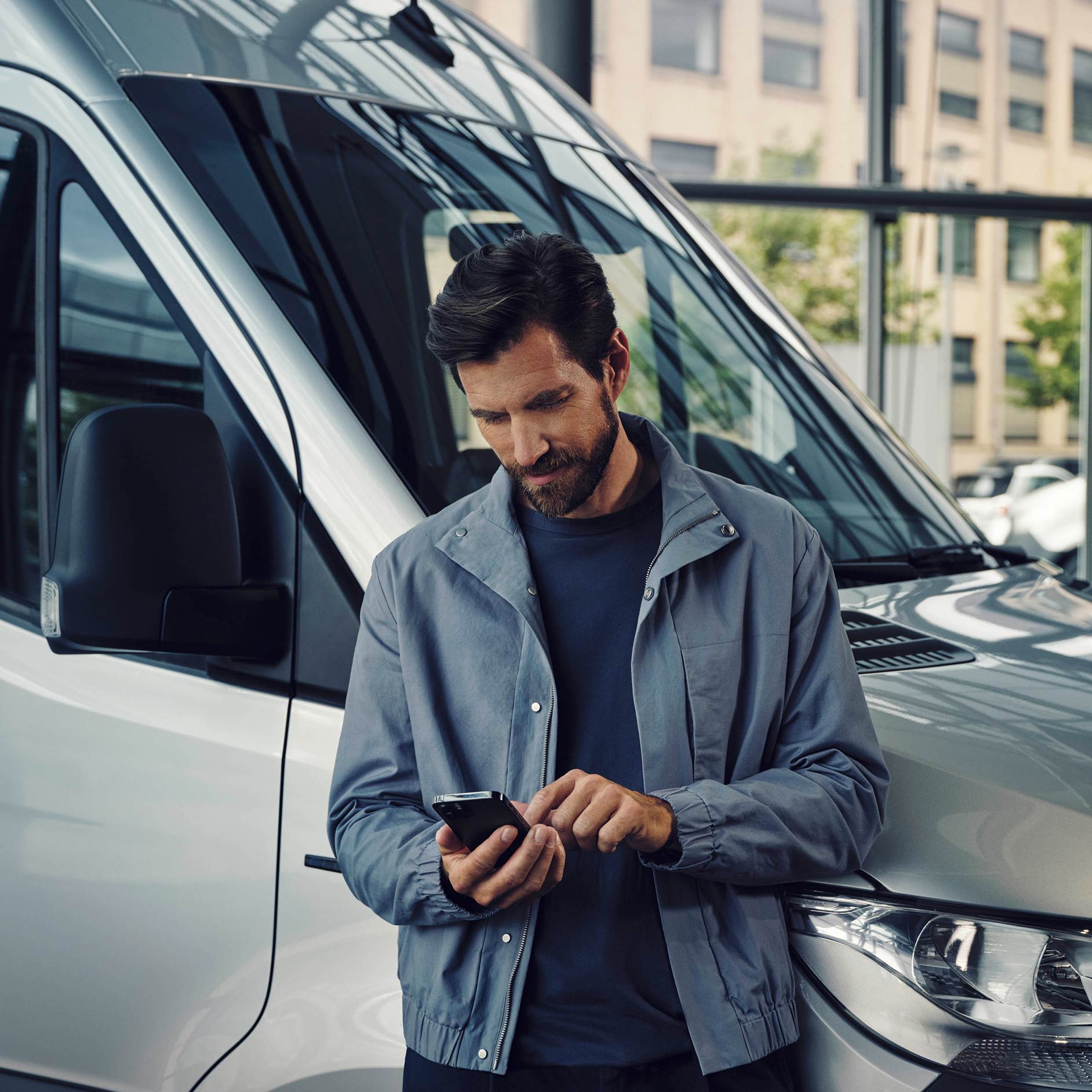 訂租計劃 | 金融服務 | Mercedes-Benz小型商用車 一位男士站在一輛白色Mercedes-Benz eSprinter輕型客貨車旁邊打電話