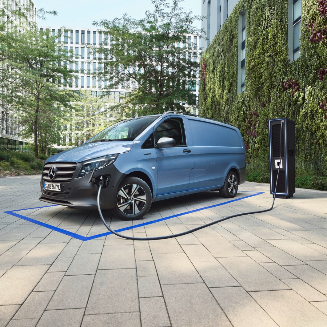 The Mercedes-Benz eSprinter, eCitan and eVito are lined up on display, with the eVito docked at a charging station.