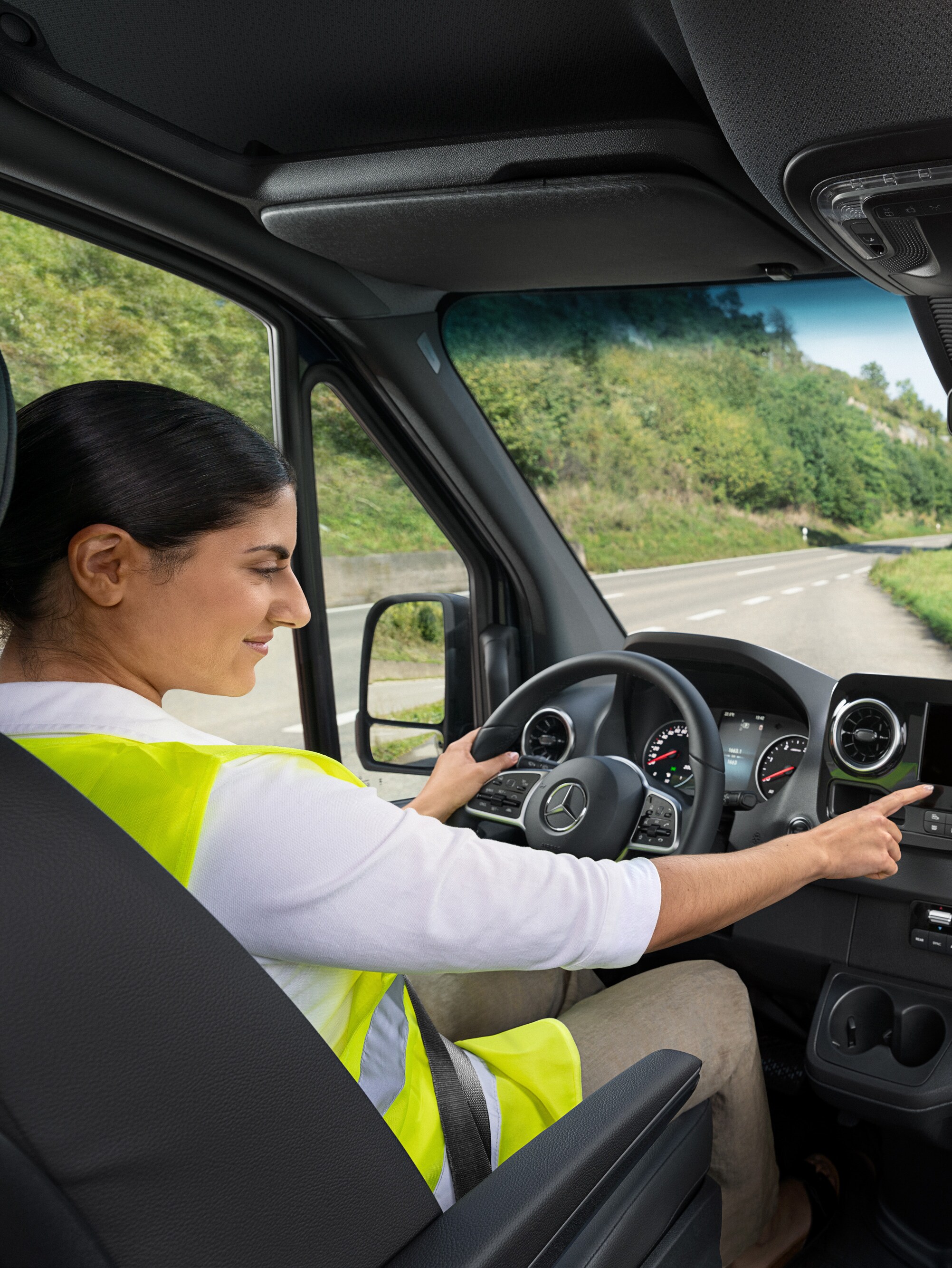 Driver in a Mercedes-Benz Sprinter calls the Mercedes-Benz Service24h hotline via the on-board menu if she has a problem.