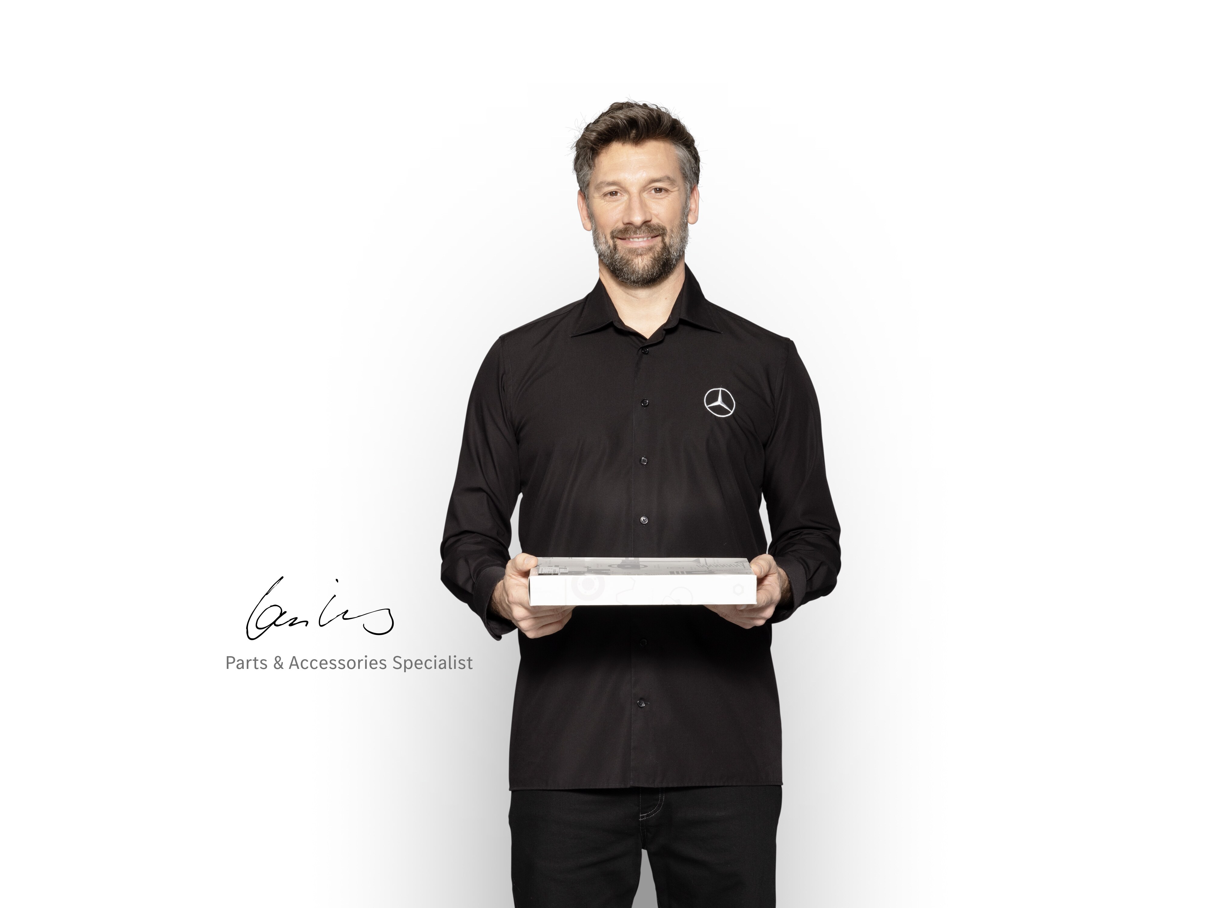 Mercedes-Benz 內部技術人員手持一個盒子展示 Mercedes-Benz 原廠零件。