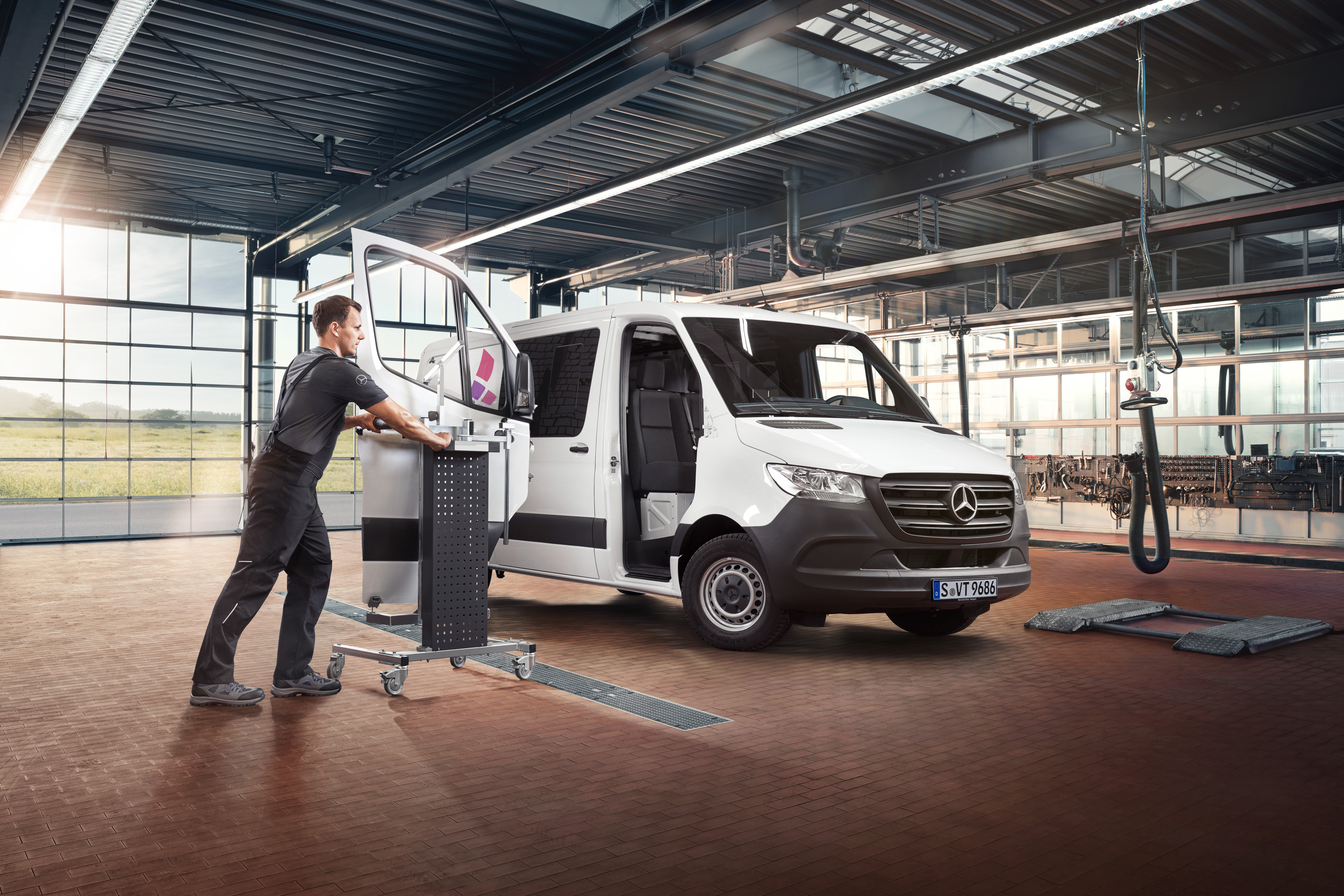 Mercedes-Benz | 服務概覽 | 維修 一名技術人員在保養一輛白色 Mercedes-Benz Sprinter小型商用車的乘客車門。