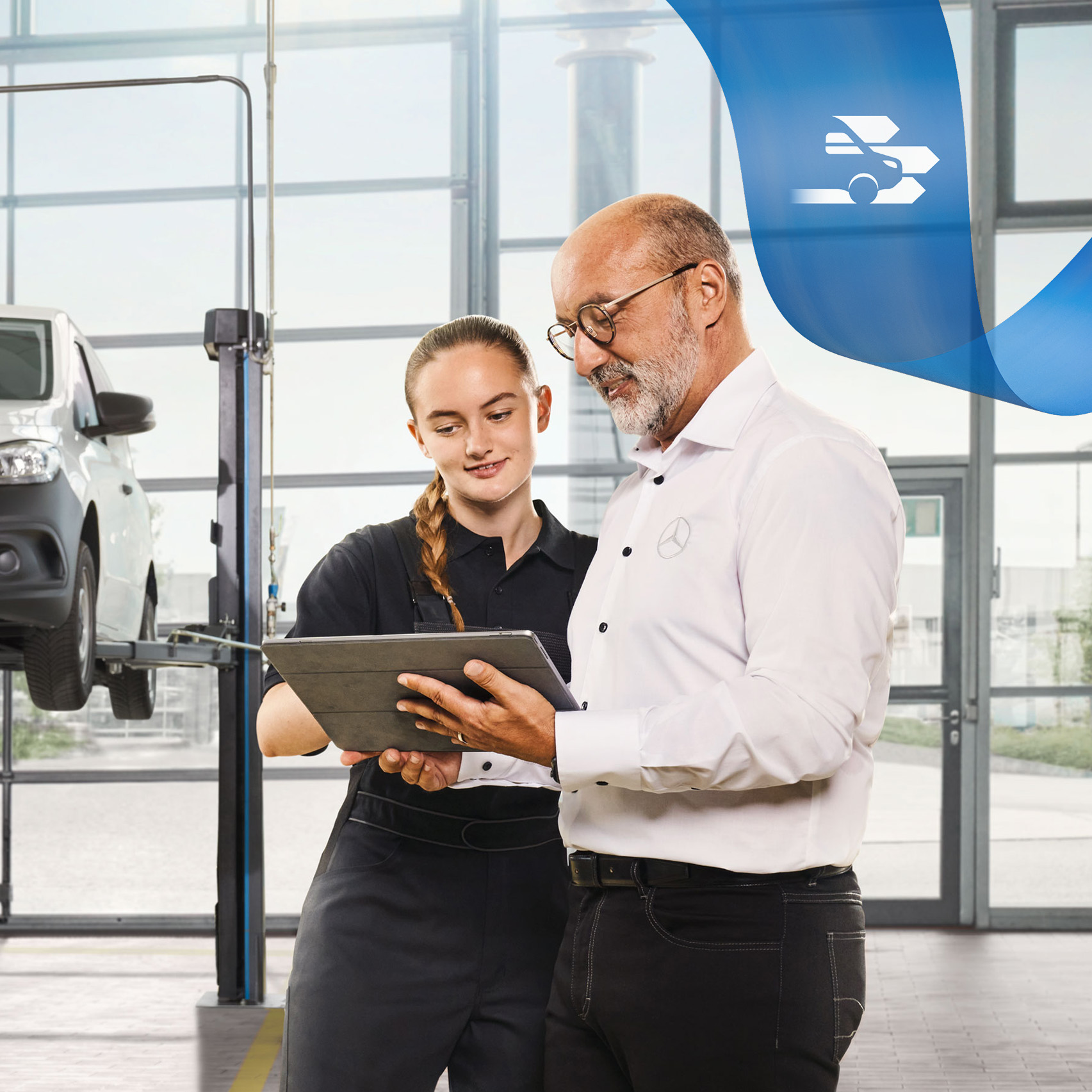 Mercedes-Benz | 保養 兩名員工在維修廠討論一輛被頂升的 Mercedes-Benz 小型商用車的商用車服務。