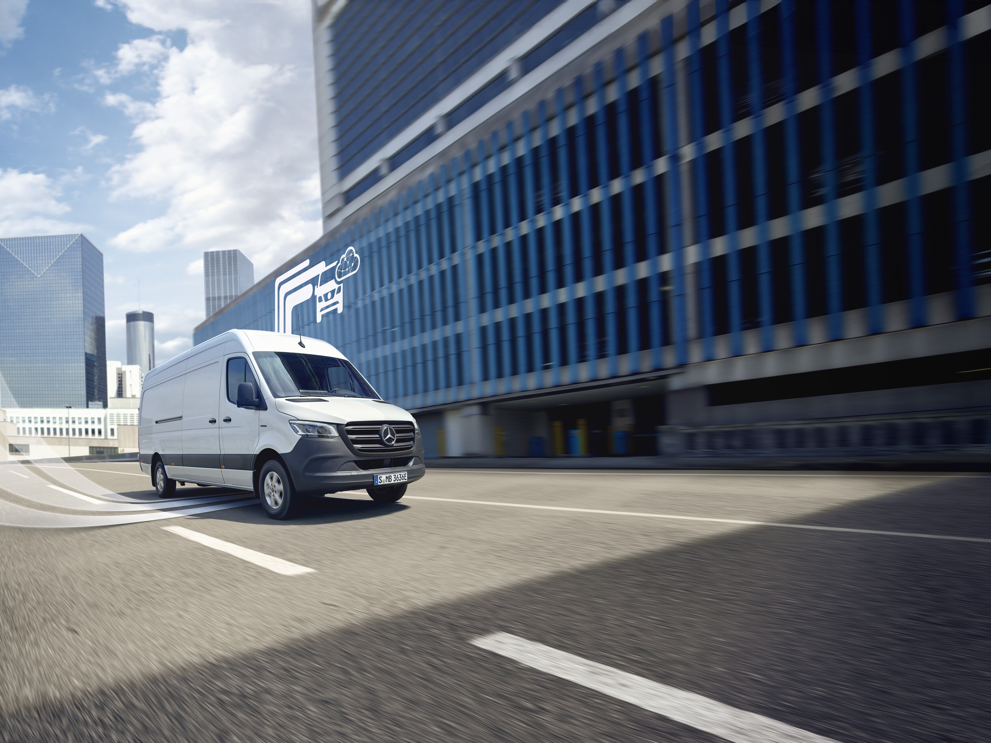 White Mercedes-Benz van driving through the city, digital symbol of Mercedes-Benz technology in the background. 