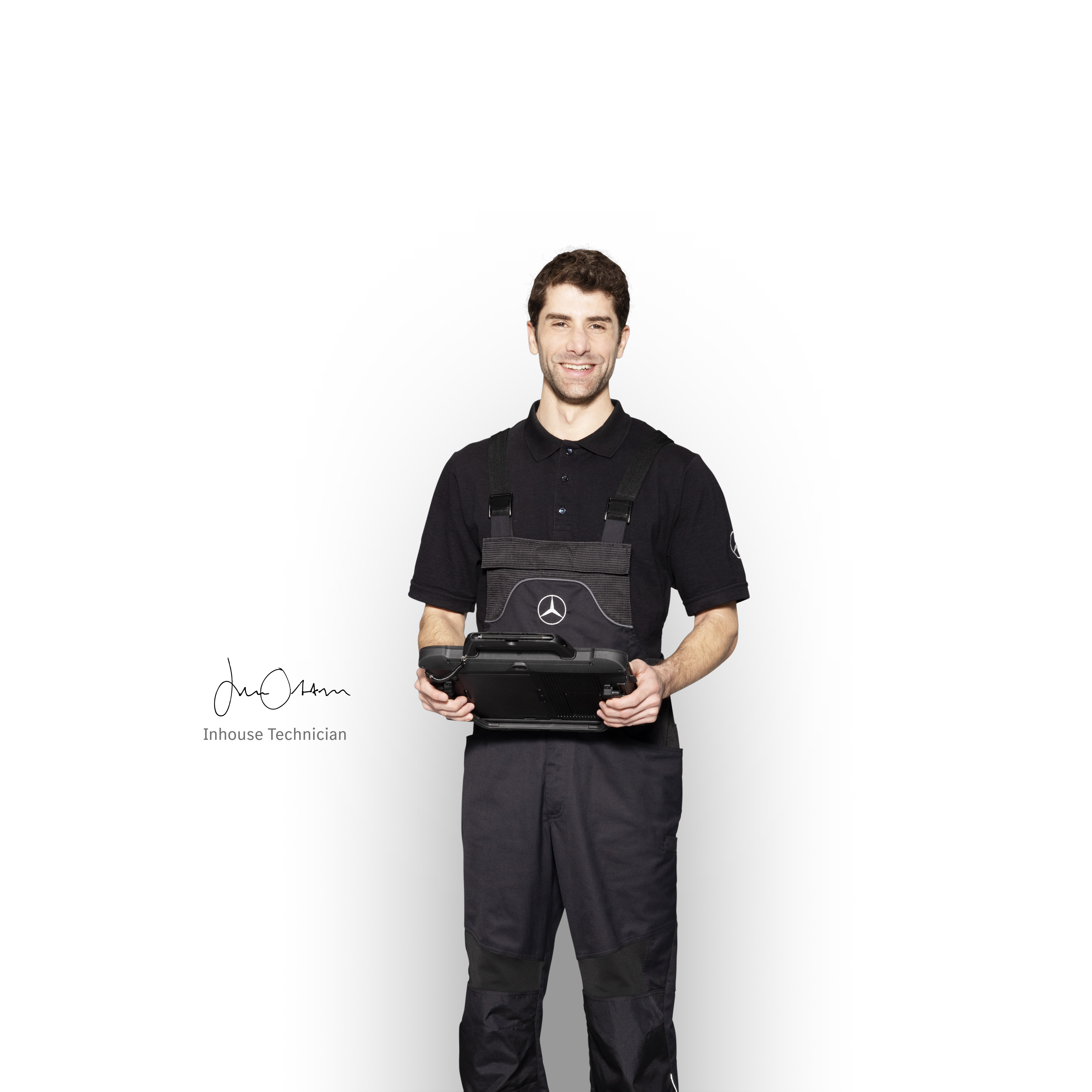 Mercedes-Benz | Services Overview Mercedes-Benz in-house mechanic in work clothes holding a tablet ready for damage reporting.